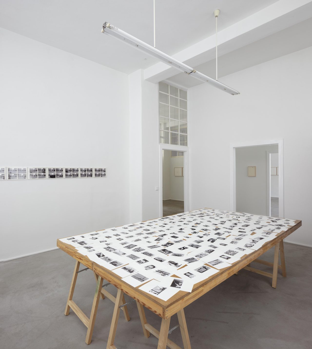 Vordergrund: Hans-Peter Feldmann: Enzyklopädie (KB 60), Straßenkreuzung (36 Fotos aus der Zeit-Serie); Hintergrund: Peter Piller: Bürozeichnung „Man sagt, die Wohnung des Chefs sei ganz in weiß eingerichtet“ (2000); Matthias Poledna: Untitled (Animation Drawing) (2013)